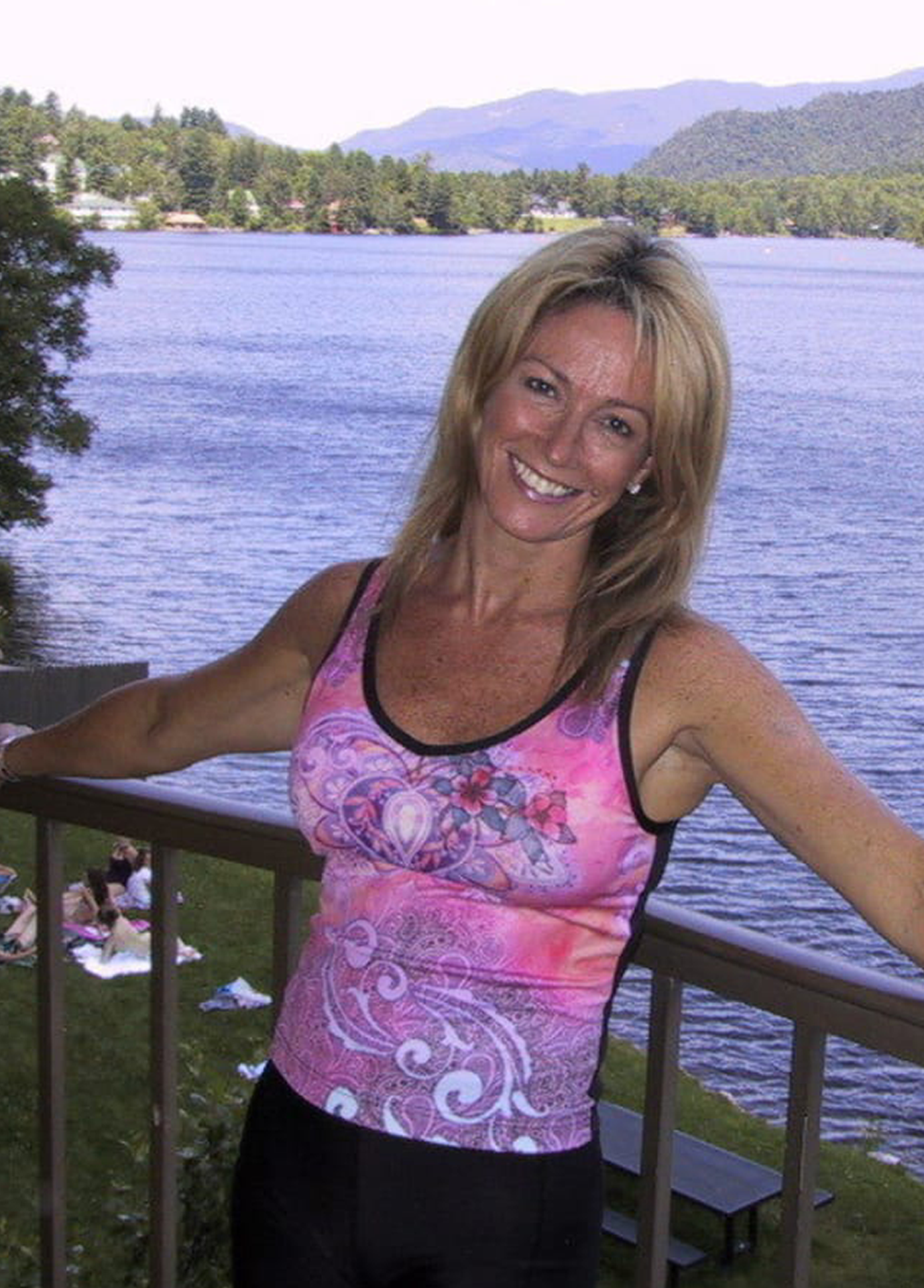 Debbie Grosser smiling beside a lake and mountains